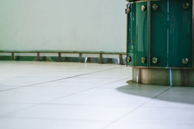 Close-up of green metal on tiled floor