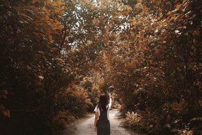 Woman standing amidst trees in forest