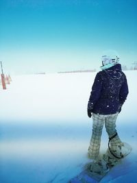 Man standing in snow against sky during winter