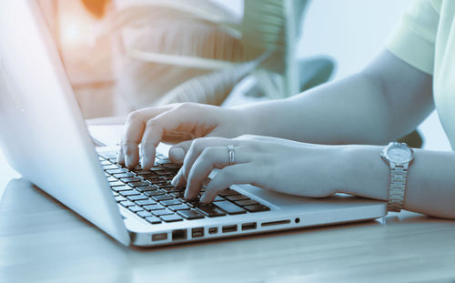 Midsection of man using laptop on table