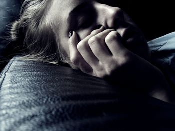 Close-up of young woman sleeping on sofa at home