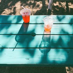 High angle view of juice in disposable glass on wooden table