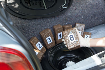 Cropped hand of person holding packet in car