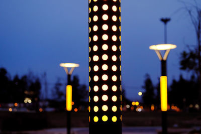 Illuminated street light against building at night