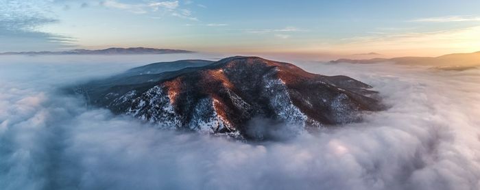 Scenic view of snowcapped mountains against sky during sunset