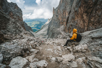 Man sitting on rock against mountains