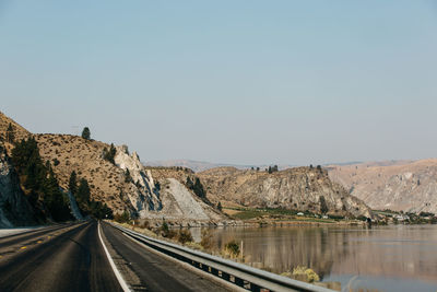 Road by mountain against clear sky