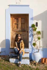 Smiling woman sitting on steps by door