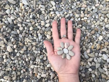 Cropped hand holding pebbles
