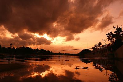 Scenic view of dramatic sky over lake during sunset