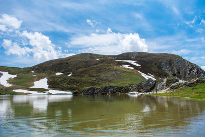 Scenic view of lake by mountain against sky