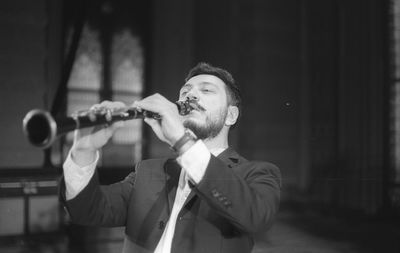 Man playing clarinet while standing at studio