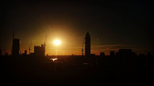 Silhouette of buildings against sky at sunset