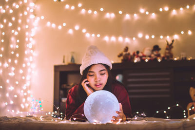 Portrait of woman with illuminated christmas lights