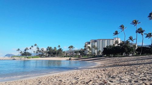 Scenic view of beach against clear blue sky