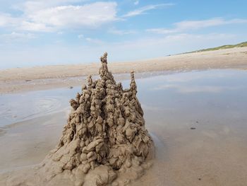 Sand castle on beach against sky