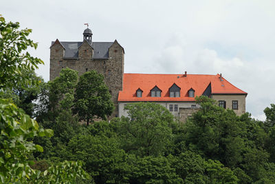 Exterior of historic building by trees against sky