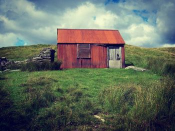 Barn on grass against sky