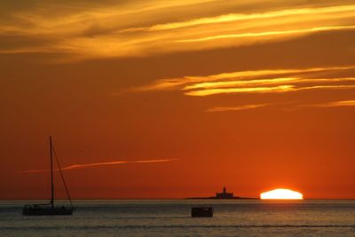 Scenic view of sea against orange sky