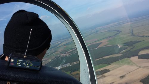 Rear view of man sitting in airplane against sky