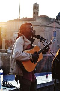 Man playing guitar in city