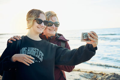 Happy women making video call on smartphone during trip on summer vacation. taking selfie photos