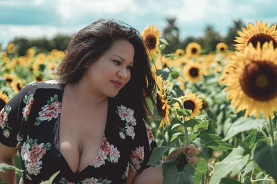 Close-up of woman with sunflowers on field