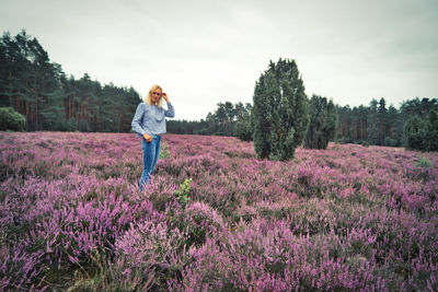 Portrait of woman standing on land amidst flowering plants