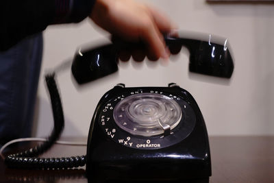 Cropped image of person holding telephone receiver