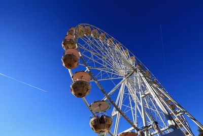 Low angle view of ferris wheel against blue sky