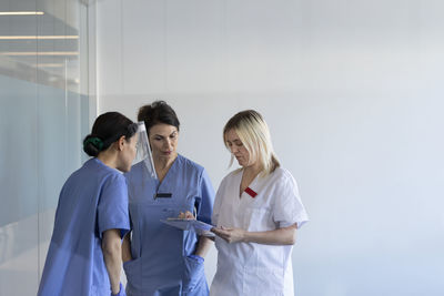 Female nurses and doctor checking file