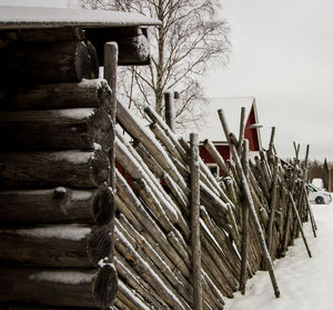 Stack of wood against sky during winter