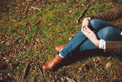 Midsection of woman sitting on field at richmond park