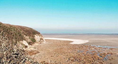 Scenic view of beach against clear blue sky