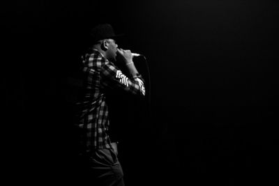 Man standing against black background