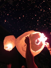 Low angle view of illuminated lantern against sky at night