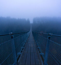 Diminishing perspective of footbridge during foggy weather
