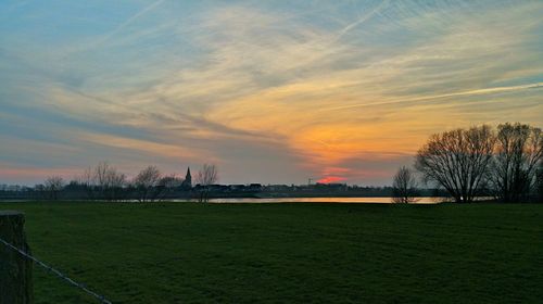 Scenic view of field against sky at sunset