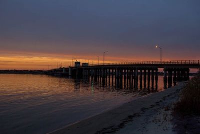 Pier on sea at sunset