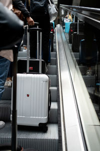 Low section of people walking on escalator