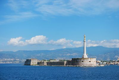 Madonnina del porto statue in sea against sky