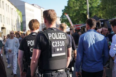 Rear view of people standing in city