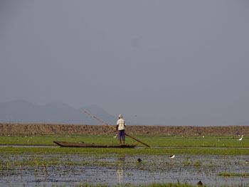 Man working on field against clear sky