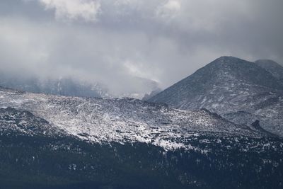 Scenic view of mountains against cloudy sky during winter