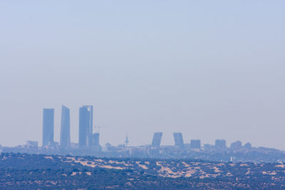 Modern buildings in city against clear sky