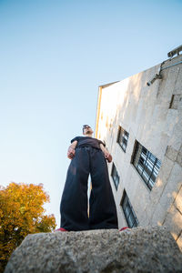 Low angle view of man standing against building