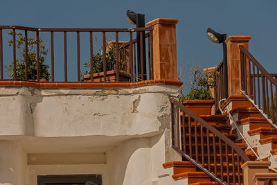 Low angle view of staircase by building against clear sky