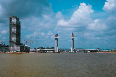 Lighthouse by sea against sky in city