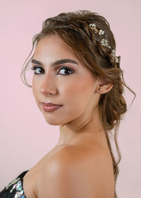 Portrait of young woman looking away against white background