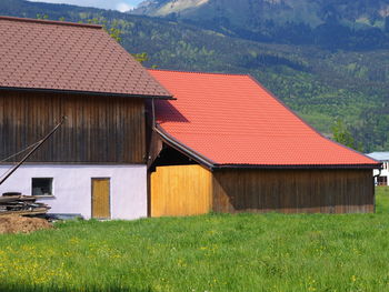 Houses on field against buildings